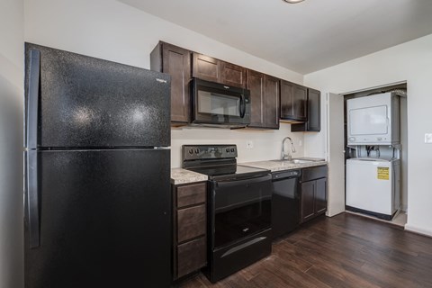 a kitchen with black appliances and dark wood cabinets